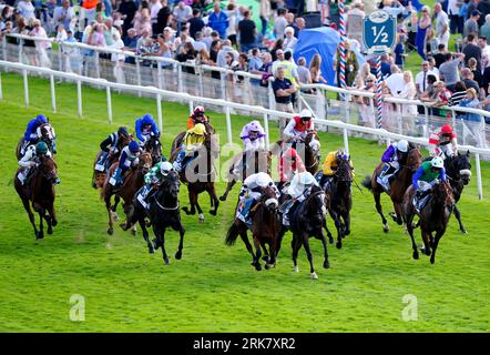 Corridori e piloti in azione mentre gareggiano nell'Or8Wellness EBF Stallions Nursery handicap il secondo giorno dello Sky Bet Ebor Festival all'ippodromo di York. Data foto: Giovedì 24 agosto 2023. Foto Stock