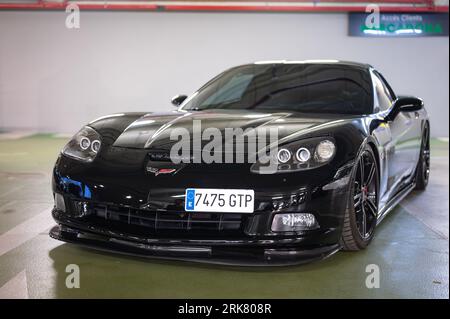 Vista frontale di una classica auto sportiva americana, la Chevrolet Corvette C6 Z51 nera parcheggiata in un parcheggio sotterraneo Foto Stock