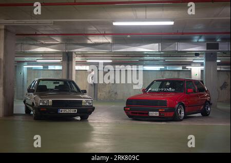Classica Volkswagen Santana GX5 grigio argento parcheggiata accanto a una Volkswagen Golf Mk2 GTI rossa Foto Stock