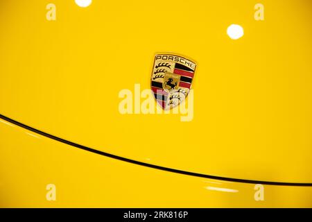 A closeup of a yellow Porsche Cayman car under the bright light Foto Stock