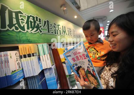 Bildnummer: 53984537 Datum: 27.04.2010 Copyright: imago/Xinhua (100428) -- PECHINO, 28 aprile 2010 (Xinhua) -- Una madre mostra un libro a suo figlio di fronte a una libreria a basso tenore di carbonio nel Beijing Book Building a Pechino, Cina, 27 aprile 2010. Una raccolta di libri sul tema delle basse emissioni di carbonio e della protezione dell'ambiente è stata accolta di recente dal pubblico. (Xinhua/Chen Xiaogen) (Ly) (3)CHINA-BEIJING-BOOK-ENVIRONMENT PROTECTION (CN) PUBLICATIONxNOTxINxCHN Gesellschaft kbdig xmk 2010 quer o0 Buchgeschäft, Buch, Ökologie Bildnummer 53984537 Date 27 04 2010 Copyright Imago XINHUA Beiji Foto Stock