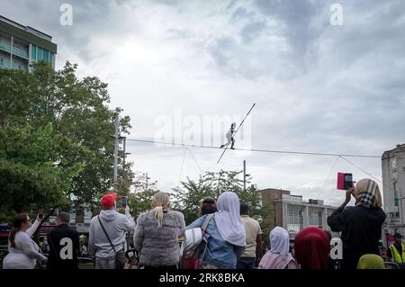 Londra, Regno Unito. 24 agosto 2023. La famosa camminatrice a corda stretta Tatiana Mosio Bongonga attraversa General Gordon Square a Woolwich, aprendo il Greenwich+Docklands International Festival 2023. Lo spettacolo mozzafiato di Open Lines celebra l'atto di intrepido ottimismo con l'importanza dell'impegno collettivo per creare insieme e speranza. Crediti: Guy Corbishley/Alamy Live News Foto Stock