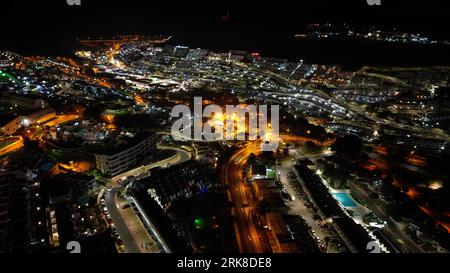 Una vista aerea di uno stupefacente paesaggio urbano fronte spiaggia illuminato da luminose luci della città da un edificio torreggiante Foto Stock