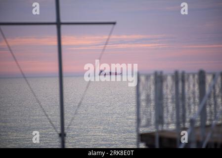 Binz auf Ruegen - 12 agosto 2023: Una petroliera GNL è ancorata all'alba al largo della costa tedesca di Ruegen Foto Stock