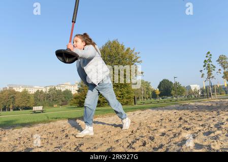 Giovane ragazza che cavalca un bungee appeso al parco giochi. Divertimento all'aperto Foto Stock