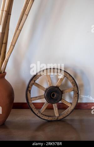 Decoration of a country house. Wooden wheel and clay vase Foto Stock