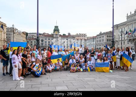 Trieste, Italia. 24 agosto 2023. I residenti ucraini mostrano le loro bandiere nazionali mentre celebrano il 32° giorno dell'indipendenza dell'Ucraina nel porto Adriatico di Trieste, Italia. La manifestazione tenutasi nella centralissima Piazza Unità d'Italia faceva parte di una "catena di unità" organizzata dalle comunità ucraine di tutto il mondo per dimostrare la loro resilienza, dignità e sostegno al loro paese, invasa dalla Russia esattamente 18 mesi fa. Crediti: Enrique Shore/Alamy Live News Foto Stock