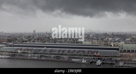 Stazione centrale dei treni di Amsterdam accanto ai canali del centro città ad Amsterdam, Paesi Bassi, un importante snodo per treni olandesi e internazionali. Foto Stock