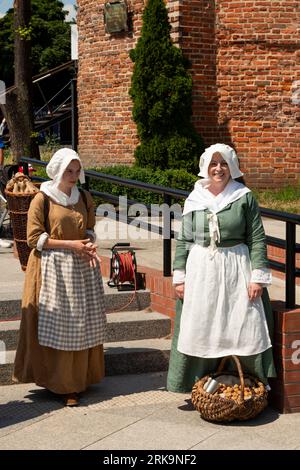 Female reenactors portray medieval street sellers at Targ Rybny or Fish Market in the Old Town of Gdansk, Poland Stock Photo