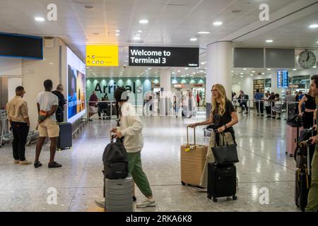 I passeggeri che arrivano al Terminal 3 dell'Aeroporto Heathrow di Londra, passano nella sala degli arrivi Foto Stock