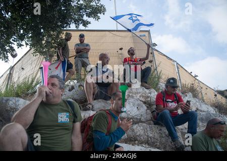 Israele. 24 agosto 2023. I manifestanti usano la vuzvuzela e sventolano la bandiera israeliana durante una manifestazione di "Brothers in Arms", organizzazione riservista israeliana contro la revisione giudiziaria di fronte a Bezalel Smotrich - ministro delle Finanze nell'insediamento occupato della Cisgiordania di Kedumim. Kedumim, la Cisgiordania. 24 agosto 2023. (Matan Golan/Sipa USA). Credito: SIPA USA/Alamy Live News Foto Stock