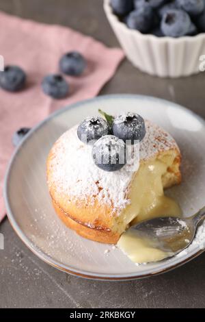 Tasty vanilla fondant with white chocolate and blueberries on grey table Foto Stock