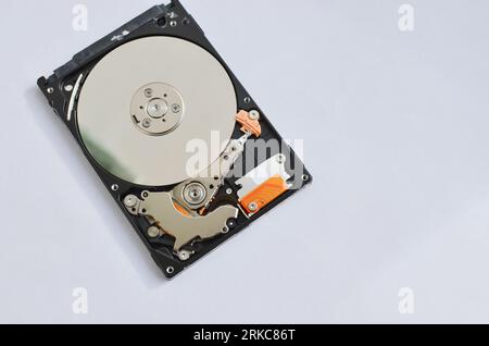 Dettaglio di un disco fisso per notebook evidenziato, a simboleggiare il supporto tecnico e il progresso tecnologico. Concetto tra assistenza tecnica e tecnologia Foto Stock