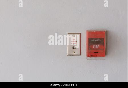 Red fire alarm switch on concrete wall in office building Industrial Emergency Fire Alarm System Equipment Stock Photo