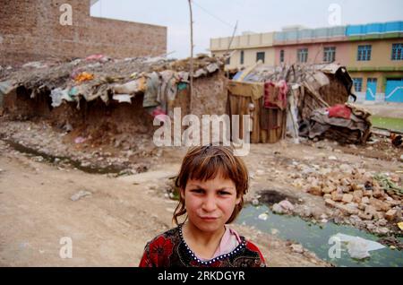 Bildnummer: 54948445 Datum: 24.02.2011 Copyright: imago/Xinhua (110224) -- PESHAWAR, 24 febbraio 2011 (Xinhua) -- una ragazza afghana rifugiata guarda alla telecamera accanto alla sua casa in una baraccopoli alla periferia del nord-ovest del Pakistan S Peshawar il 24 febbraio 2011. Il governo pakistano e l'agenzia delle Nazioni Unite per i rifugiati hanno raggiunto un accordo nel marzo 2009 per consentire a circa 1,7 milioni di rifugiati afghani registrati che vivono in Pakistan di continuare a ripararsi lì almeno fino al 2012. Migliaia di loro vivono ancora senza elettricità, acqua corrente e altri servizi di base. (Xinhua/Saeed Ahmad) (ypf) PAKISTAN-PE Foto Stock