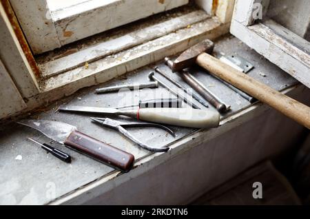 Riparazione del vecchio finestrino danneggiato o smontaggio prima di installare il nuovo primo piano. Riparazione di un telaio di una finestra, utilizzando strumenti per la ristrutturazione di vecchie finestre Foto Stock