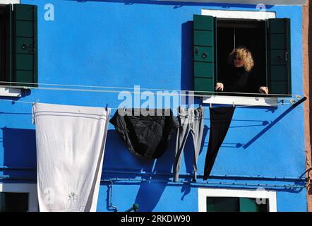 Bildnummer: 55009278  Datum: 08.03.2011  Copyright: imago/Xinhua VENICE, March 9, 2011 (Xinhua) -- A woman stretches out to air clothes from the window of her brightly-painted house at Burano, an outlying island northeast of Venice, Italy, March 8, 2011. Villagers of the island have a long tradition to paint their houses colorfully, which today have become the main feature of the island. (Xinhua/Wang Qingqin) (wjd) ITALY-VENICE-BURANO ISLAND PUBLICATIONxNOTxINxCHN Reisen ITA Gesellschaft kbdig xng 2011 quer Aufmacher premiumd o0 Wäsche trocknen Wäscheleine Fenster    Bildnummer 55009278 Date 0 Stock Photo