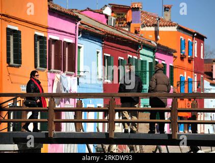 Bildnummer: 55009284  Datum: 08.03.2011  Copyright: imago/Xinhua VENICE, March 9, 2011 (Xinhua) -- Tourists walk on a bridge to view the brightly-painted houses at Burano, an outlying island northeast of Venice, Italy, March 8, 2011. Villagers of the island have a long tradition to paint their houses colorfully, which today have become the main feature of the island. (Xinhua/Wang Qingqin) (wjd) ITALY-VENICE-BURANO ISLAND PUBLICATIONxNOTxINxCHN Reisen ITA Gesellschaft kbdig xng 2011 quer premiumd o0 Brücke Gebäude Wohngebäude    Bildnummer 55009284 Date 08 03 2011 Copyright Imago XINHUA Venice Stock Photo