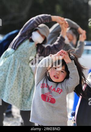 Bildnummer: 55204062  Datum: 02.04.2011  Copyright: imago/Xinhua RIKUZENTAKATA (Japan), April 2, 2011 (Xinhua) -- Ki Haru, a 4-year-old Japanese girl does physical exercises with others regugees at a makeshift refugee camp in Rikuzentakata, one of the cities worst hit by Friday s 9 Magnitude quake and ensuing tsunami, Iwate Prefecture, Japan, April 2, 2011. The coastal city of Rikuzentakata in Iwate Prefecture was devastated by a tsunami wave, the landscape was virtually submerged, with only a few buildings remaining in the urban area. (Xinhua/Ji Chunpeng) (zyw)) JAPAN-RIKUZENTAKATA-REFUGEE CA Stock Photo