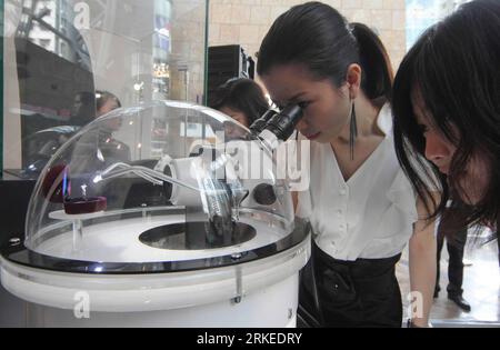 Bildnummer: 55244014  Datum: 07.04.2011  Copyright: imago/Xinhua (110407) -- HONG KONG, April 7, 2011 (Xinhua) -- A girl watches the Starry Lovers , a micro-sculpture artwork on top of a diamond ring by micro-sculpture artist Willard Wigan from England during a media preview of an exhibition in Hong Kong, south China, April 7, 2011. The exhibition, which is the first time Willard Wigan s micro-sculptures on display in Asia, will open to the public from April 8 to 10. (Xinhua/Du Hai)(xzj) CHINA-HONG KONG-MICRO SCULPTURE-EXHIBITION (CN) PUBLICATIONxNOTxINxCHN Kultur Objekte kbdig xsk 2011 quer Stock Photo