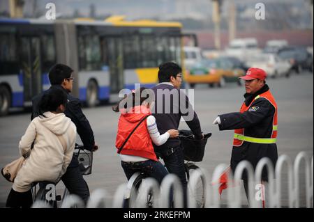 Bildnummer: 55250224 Datum: 06.04.2011 Copyright: imago/Xinhua PECHINO, 9 aprile 2011 (Xinhua) - Meng Xianwu (R) ordina a due ciclisti di smettere di portare ragazze in bici, a Pechino, Cina, 6 aprile 2011. Meng Xianwu, 46 anni, un assistente della polizia stradale, lavora in un posto stradale situato sulla Xicelu Road o sulla strada ovest vicino alla famosa Piazza Tian anmen nel centro di Pechino, quindi Meng è soprannominato l'assistente della polizia stradale più vicino alla Piazza Tian anmen . Il compito di Meng è quello di aiutare i poliziotti a mantenere gli ordini stradali e mostrare indicazioni per numerosi visitatori fuori città. (Xinhua/Wang Jianwei)(hdt) Foto Stock