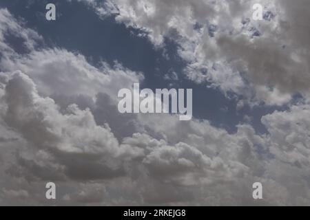 Una foto accattivante cattura la bellezza dei giorni nuvolosi, dove la tela del cielo è adornata con varie sfumature di nuvole, creando un'incantevole giocata Foto Stock