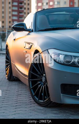 BMW Z4 grigia al tramonto della città. Foto Stock