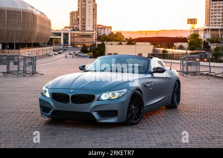 BMW Z4 grigia al tramonto della città. Foto Stock