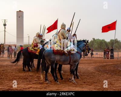 Essaouira, Marocco - 13 agosto 2023: Gli equestri che partecipano a un tradizionale evento di abiti fantasiosi chiamato Tbourida vestito in un tradizionale marocchino Foto Stock