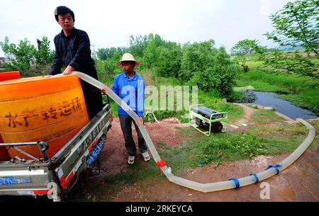 Bildnummer: 55315377 Datum: 04.05.2011 Copyright: imago/Xinhua (110504) -- MACHENG, 4 maggio 2011 (Xinhua) -- campi d'acqua degli abitanti del villaggio con rifornimento d'acqua da un tronco nella città di Macheng, provincia di Hubei della Cina centrale, 4 maggio 2011. Una grave siccità ha colpito la provincia di Hubei dal novembre del 2010, portando un terzo delle sue contee e città sotto una grave carenza idrica. Il governo locale sta adottando misure per combattere la siccità e garantire la sua aratura primaverile. Alcuni agricoltori locali hanno rinunciato alla piantagione di riso rivolgendosi alle colture adatte alla terra secca, come il cotone. (Xinhua/Cheng min) ( Foto Stock