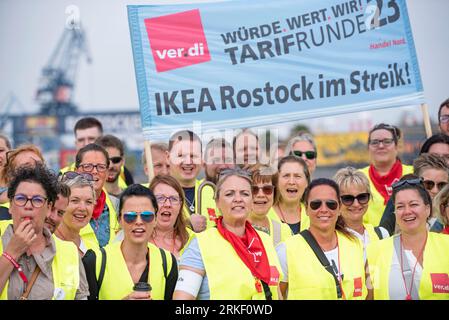 Rostock, Germania. 25 agosto 2023. I membri di Verdi Nord arrivano a una manifestazione nel porto della città di Rostock. Il sindacato dei servizi Verdi Nord invita i circa 175.000 dipendenti dello Schleswig-Holstein e del Meclemburgo-Pomerania occidentale nel commercio al dettaglio e nel commercio all’ingrosso e all’esportazione a partecipare a uno sciopero di due giorni il 25 e 26 agosto. Crediti: Frank Hormann/dpa/Alamy Live News Foto Stock
