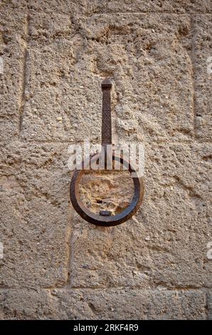 Antico anello di ferro nelle mura per legare cavalli, asini e muli, villaggio di chiusi, Siena, Toscana Foto Stock
