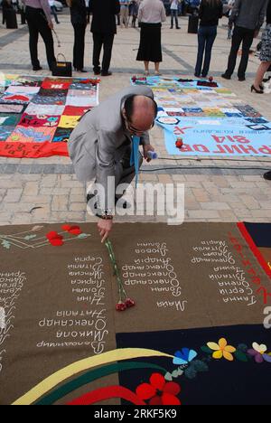 Bildnummer: 55348418  Datum: 13.05.2011  Copyright: imago/Xinhua KIEV, May 14, 2011 (Xinhua) -- A man lays flowers on the quilts laying on Mikhaylovskaya Square in Kiev on May 13, 2011. Created by HIV positive people, quilts covering the area of some 300 square metres of tje square were on display on Friday to commemorate AIDS victims in Ukraine. (Xinhua/Valeriia Lashkul)(sqq) UKRAINE-AIDS-QUILTS PUBLICATIONxNOTxINxCHN Gesellschaft Gedenken Aidsopfer o0 Opfer Aids o0 kbdig xsk 2011 hoch o0 Blume    Bildnummer 55348418 Date 13 05 2011 Copyright Imago XINHUA Kiev May 14 2011 XINHUA a Man Lays Fl Stock Photo