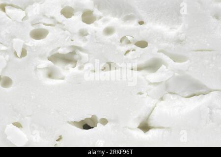 Vista dall'alto del formaggio casalingo. La consistenza del formaggio casalingo. Consistenza di formaggio bianco macro. Foto Stock