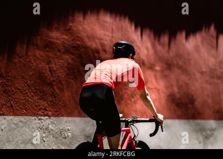 Giri in bicicletta su strada di ciottoli nella città coloniale sullo sfondo rosso Foto Stock