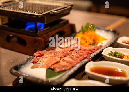 Wagyu Carni bovine su un barbecue con condimenti per immersione Foto Stock