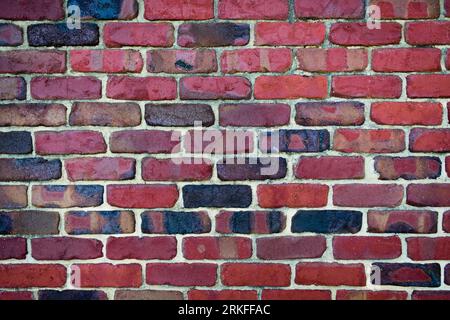 Vecchio muro in mattoni rossi vintage con colori scuri Foto Stock