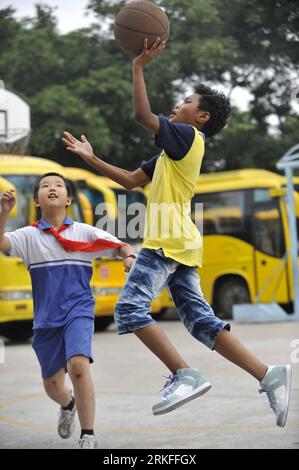 Bildnummer: 55414043 Datum: 31.05.2011 Copyright: imago/Xinhua (110531) - GUANGZHOU, 31 maggio 2011 (Xinhua) - Lu Danhua (R) gioca a basket con il suo amico a Guangzhou, capitale della provincia del Guangdong della Cina meridionale, 30 maggio 2011. Con la pelle relativamente scura e i capelli arricciati, il ragazzo di dieci anni di nome Lu Danhua ha attirato l'attenzione della gente durante l'ottava attività elettorale del piccolo Sindaco di Guangzhou. Lu Danhua, figlio di un padre sudanese e di una madre cinese, il cui nome inglese è Abdoe A Mohammed, prese parte alla campagna con altri 500.000 giovani studenti a Guangzhou. Ha vinto fino in fondo Foto Stock