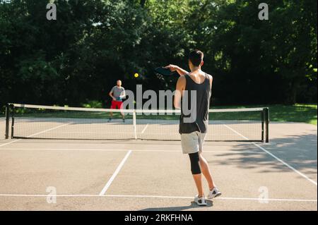 Due giovani che giocano a pickleball in estate Foto Stock