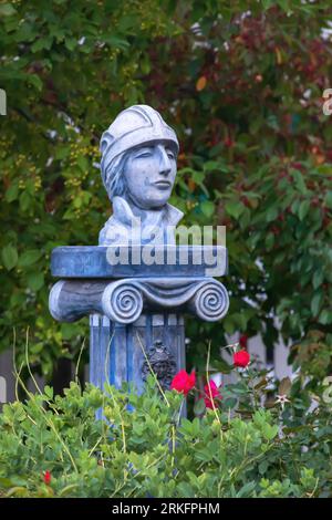 Rose rosse e un'elegante scultura intitolata "il ciclista" su una colonna ionica greca presso la storica Thomas Lacy House, costruita nel 1858 a Taylors Falls, Foto Stock