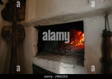 Forno tradizionale ucraino in casa. La legna da ardere brucia nel forno, preparazione per la cottura del pane. Foto Stock