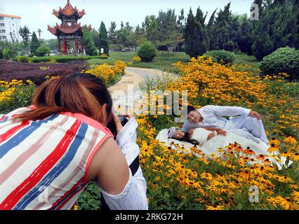 Bildnummer: 55560147 Datum: 28.06.2011 Copyright: imago/Xinhua (110630) --ZHENGZHOU, 30 giugno 2011 (Xinhua) -- Una posa di coppia per le foto di matrimonio nel villaggio di Nanjie, nella contea di Linying, nella provincia di Henan, nella Cina centrale, il 28 giugno 2011. È diverso da qualsiasi altro posto della Cina nel villaggio di Nanjie. All'entrata di Nanjie, una strada ampia e dritta termina alla piazza principale del villaggio, dove una gigantesca statua in marmo bianco del defunto presidente Mao Zedong si trova ancora al centro. (Xinhua/Wang Song) (wx) CHINA-HENAN-NANJIE VILLAGE (CN) PUBLICATIONxNOTxINxCHN Gesellschaft Fotostory po Foto Stock