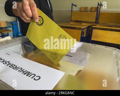 Bursa , Turchia - 28 maggio 2023: Colpo ravvicinato di una mano di un uomo che ha gettato il suo voto in un ballottaggio durante le elezioni in Turchia. Foto di alta qualità Foto Stock