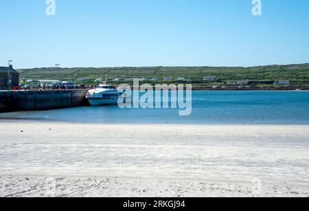 Galway, Ireland - 03 June, 2023. Ferry and sandy beach on Kilronan harbour on Inishmore, Aran Island, Co, Galway, Ireland, Stock Photo