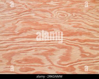 An orange-hued plywood panel with a unique texture showcasing various designs Foto Stock