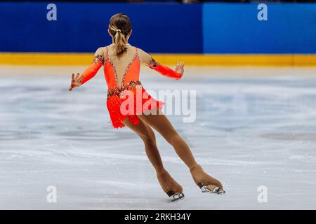 back girl figure skater in bright red dress, figure skating single Stock Photo