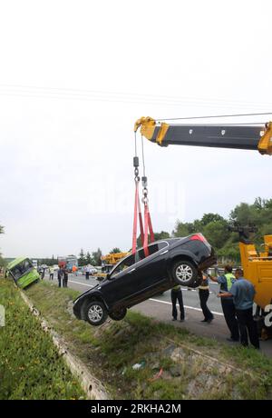 Bildnummer: 55768642 Datum: 15.08.2011 Copyright: imago/Xinhua (110815) -- CHANGCHUN, 15 agosto 2011 (Xinhua) -- Un'auto danneggiata viene sollevata nel sito di un incidente stradale nella provincia di Jilin della Cina nord-orientale, 15 agosto 2011. Quattro sono stati confermati morti e altri 17 sono rimasti feriti quando un autobus che trasportava un gruppo turistico da Taiwan si è schiantato in un fosso stradale dopo aver collidito con un'auto passeggeri su una superstrada nella provincia di Jilin della Cina nord-orientale lunedì pomeriggio. Tutti e quattro i morti, compresi un uomo e tre donne, venivano da Taiwan. Dei 17 feriti, 15 erano turisti di Taiwan. (Xinhua/Zhou Jun) (l Foto Stock