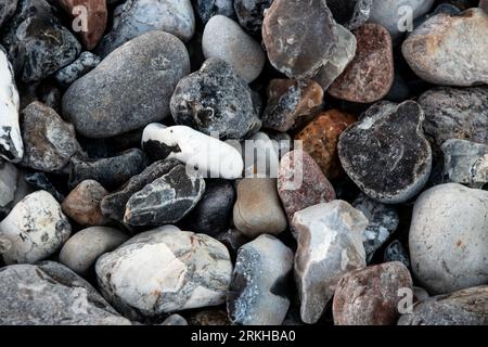 A beach landscape featuring a variety of stones of different shapes and sizes laid out in a picturesque manner Stock Photo