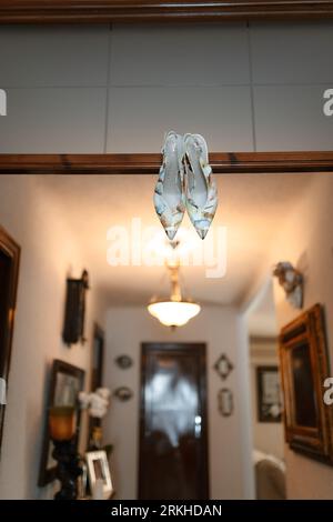 Un paio di scarpe da sposa dai colori vivaci su un soffitto dipinto di bianco, perfette per un matrimonio Foto Stock