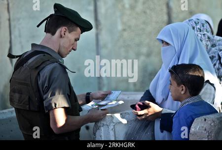 Bildnummer: 55833466 Datum: 26.08.2011 Copyright: imago/Xinhua (110826) -- CISGIORDANIA, 26 agosto 2011 (Xinhua) -- un soldato israeliano controlla le carte d'identità dei palestinesi al checkpoint israeliano di Qalandiya vicino alla città di Ramallah in Cisgiordania mentre cercano di attraversare Gerusalemme per partecipare alle preghiere dell'ultimo venerdì del mese sacro islamico del Ramadan alla Moschea di al-Aqsa, 26 agosto 2011. (Xinhua/Fadi Arouri) MIDEAST-WEST BANK-RAMADAN-LAST FRIDAY PUBLICATIONxNOTxINxCHN Gesellschaft Westjordanland Nahostkonflikt Grenzposten Grenze Kontrolle Personenkontrolle xns 2011 quer o0 Grenzkontrollen Soldat Militä Foto Stock